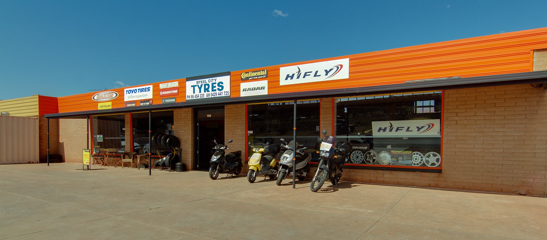 The Steel City Tyres shopfront on McBryde Terrace, Whyalla, with its orange fascia and tyre brand boards